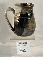 Front angled view of stoneware mug showing glaze pattern and form