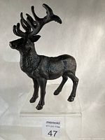 Right side view of cast iron stag standing on acrylic riser