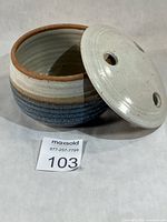 Open pot showing reddish interior and detached vented lid