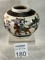 Front view of crackle-glazed porcelain ginger jar showing warrior on horseback motif and brown shoulder band