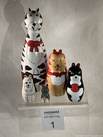 Front view of all five cat nesting dolls arranged by height
