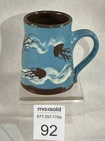 Front view of blue slipware mug with jellyfish motif