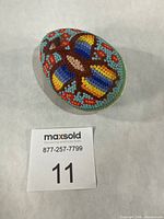 Full view of beaded egg with scale card