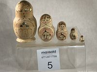 Front view of all five nesting dolls lined up by size