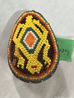 Beaded egg ornament front showing yellow lizard and central diamond pattern