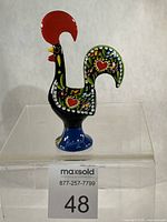Left-side view of Portugese Barcelos rooster figurine showing painted motifs and “Portugal” on base