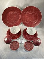 Front view of all ten red sgraffito porcelain pieces