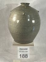 Front view of stoneware celadon vase on stand