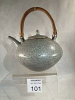 Frontal view showing crackle glaze, lid, bamboo handle