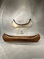 Front view of both birch bark canoes on stand