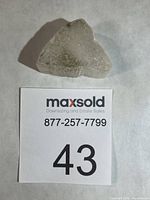 Full view of Ulexite specimen on white background with lot number card