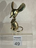 Front view of brass mouse figurine showing ears, face, body, tail