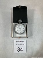 Stopwatch in open black presentation box with lot number card