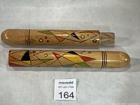 Two-piece wooden knitting needle case shown separated to display cap and body