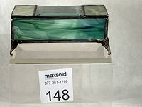 Front view of stained glass jewelry box showing green slag glass panel and feet