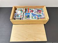 open wooden box filled with sports cards and detached lid