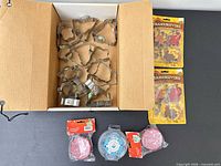 Overview of lot: box of metal cookie cutters, two Thanksgiving cutter packs, three cupcake liner packs