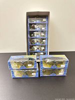 Stacked retail boxes of Pro Flare sunglasses, some inside master carton and four boxed pairs in front