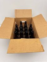 Open box showing 14 brown glass bottles in cardboard divider