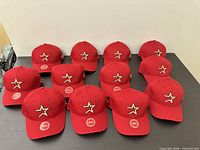 Twelve identical red Houston Astros youth caps arranged on surface