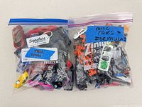 Two freezer bags filled with assorted toy cars