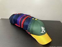 Side view of stacked caps showing mesh texture and Oakland Athletics cap