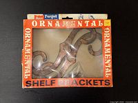 Front of box showing ornamental shelf brackets inside