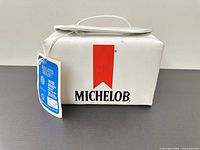 Side view of white Michelob cooler with logo and hang tag