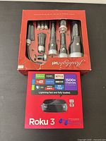 Front view of boxed Roku 3 and aluminum flashlight set