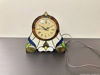 Front view of stained glass quartz desk clock with power cord visible