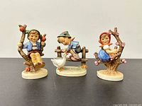 Front view of three Goebel Hummel child figurines