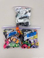 Three Ziploc bags filled with various toy race cars
