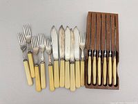 Group view of forks, knives, steak knives in wooden block