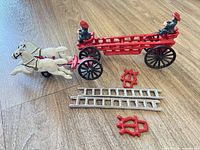 Overall shot showing horse-drawn fire wagon, ladders and brackets