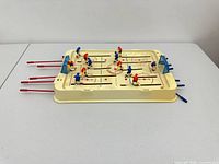 Top view of tabletop hockey game showing rink, players, rods and goals