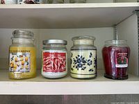 Shelf showing four jar candles together