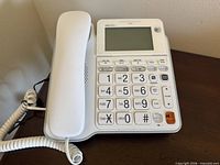 Front view of AT&T CL4940 phone showing handset, keypad, display and cords