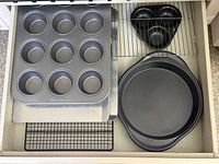 Drawer view showing all seven metal baking pieces