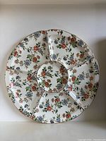 Front view of round porcelain platter showing six compartments and central well