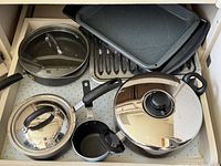 Drawer containing frying pan with lid, stockpot with lid, saucepan with lid, small saucepan, rectangular grill and griddle plates