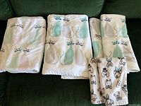 All four towels laid out: three cat print bath towels, one dog print hand towel