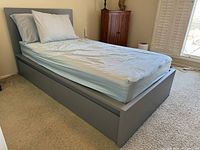 Full view of gray platform bed with headboard and mattress