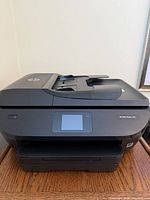 Front view of HP Envy Photo 7855 printer showing touchscreen and paper tray