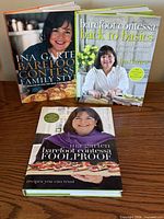 Three Ina Garten Barefoot Contessa hardcover cookbooks displayed upright and flat