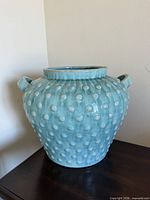 Front view of blue hobnail ceramic vase on table