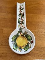 Top view of ceramic spoon rest showing lemon motif and vine-decorated handle