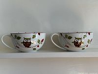 Two large owl pattern soup mugs on shelf
