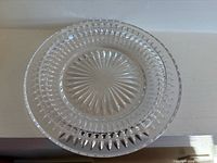 Front view of clear glass plate showing full starburst pattern and rim design