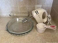 Group shot showing mixer, two pie plates, rectangular dish, measuring cups