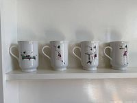 All four coffee mugs lined on shelf